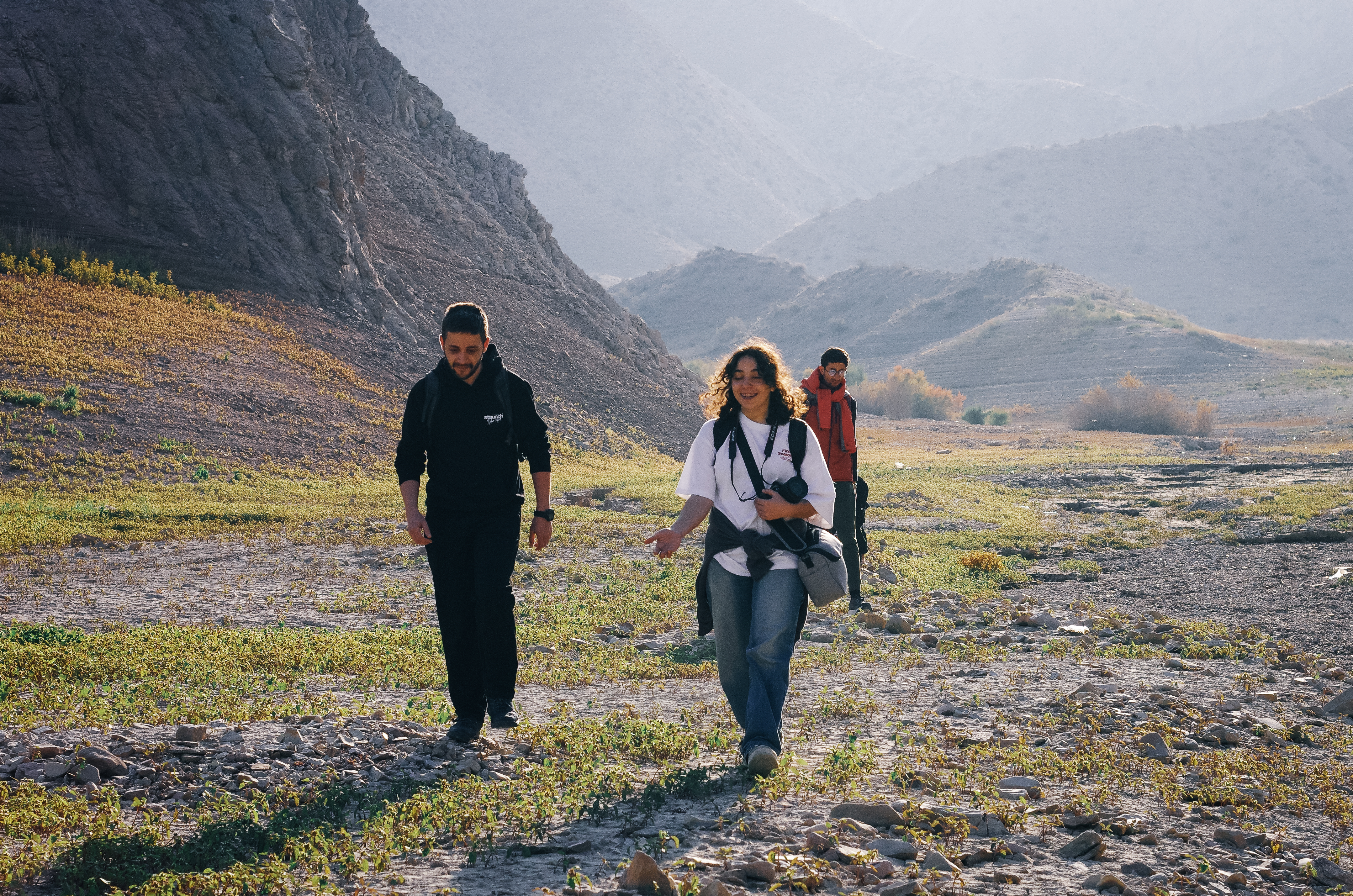 Hiker moving through a vast volcanic mountain landscape